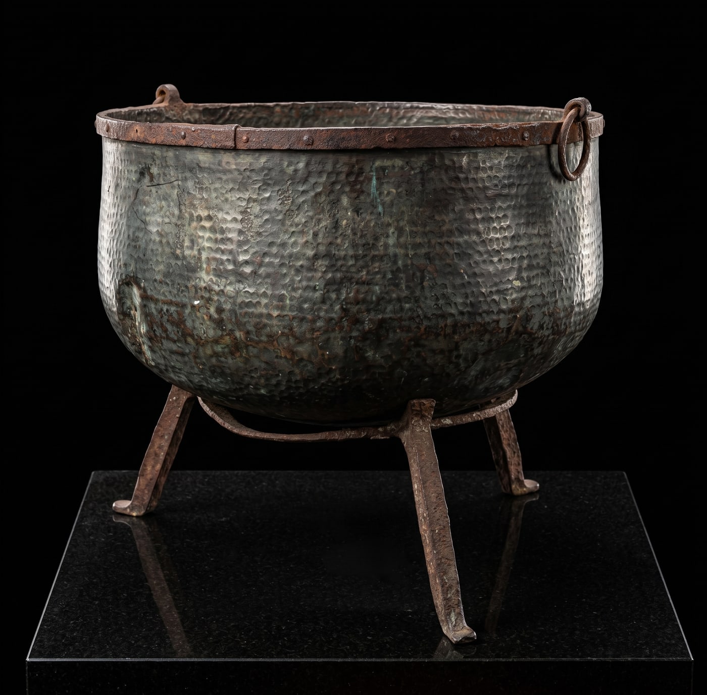 An old hammered cauldron on an iron stand